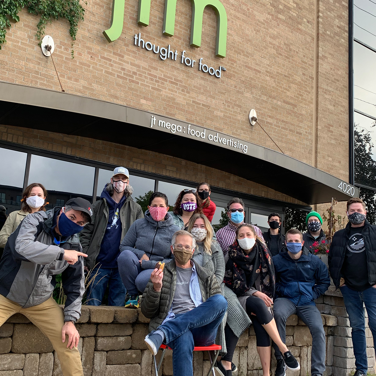 Masked creative team in front of JT Mega office