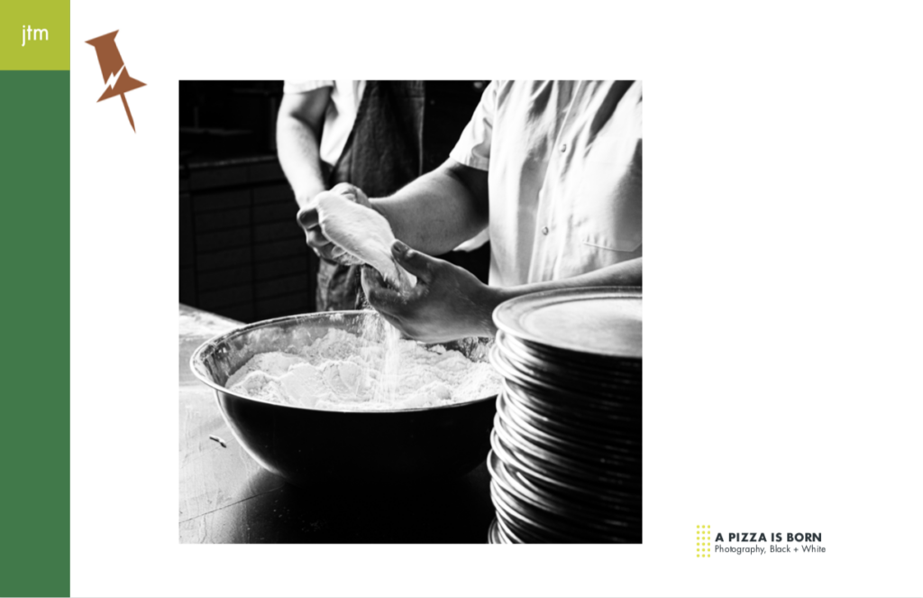 black and white shot of pizza dough coming out of bowl of flour