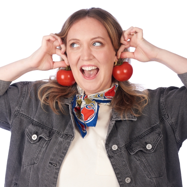 Maddie Spott holding up tomatoes as earrings
