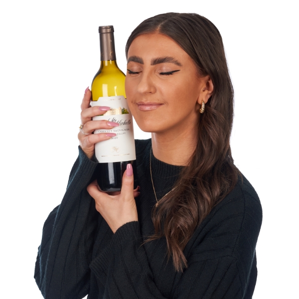 Jules holding a bottle of red wine