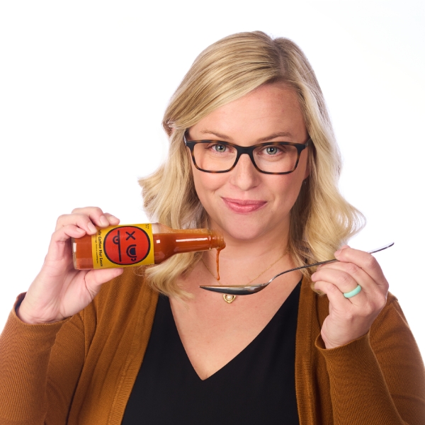 Samantha Isaacson pouring hot sauce onto a spoon